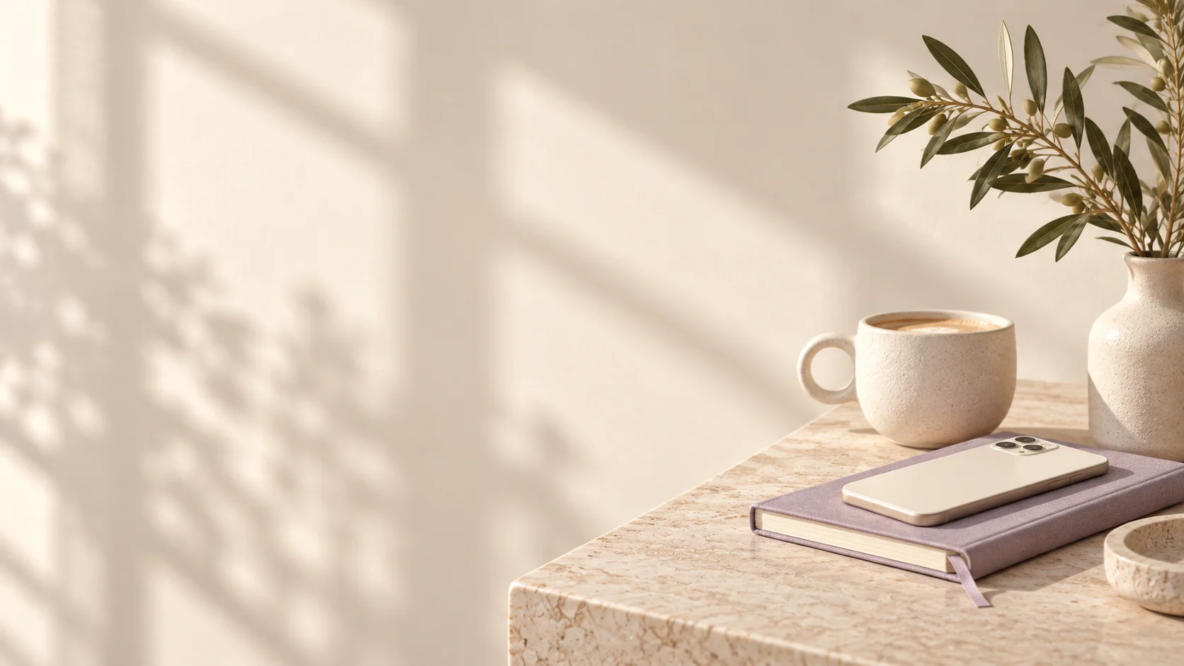 Welcoming studio still life with an ivory phone, lavender notebook and olive foliage